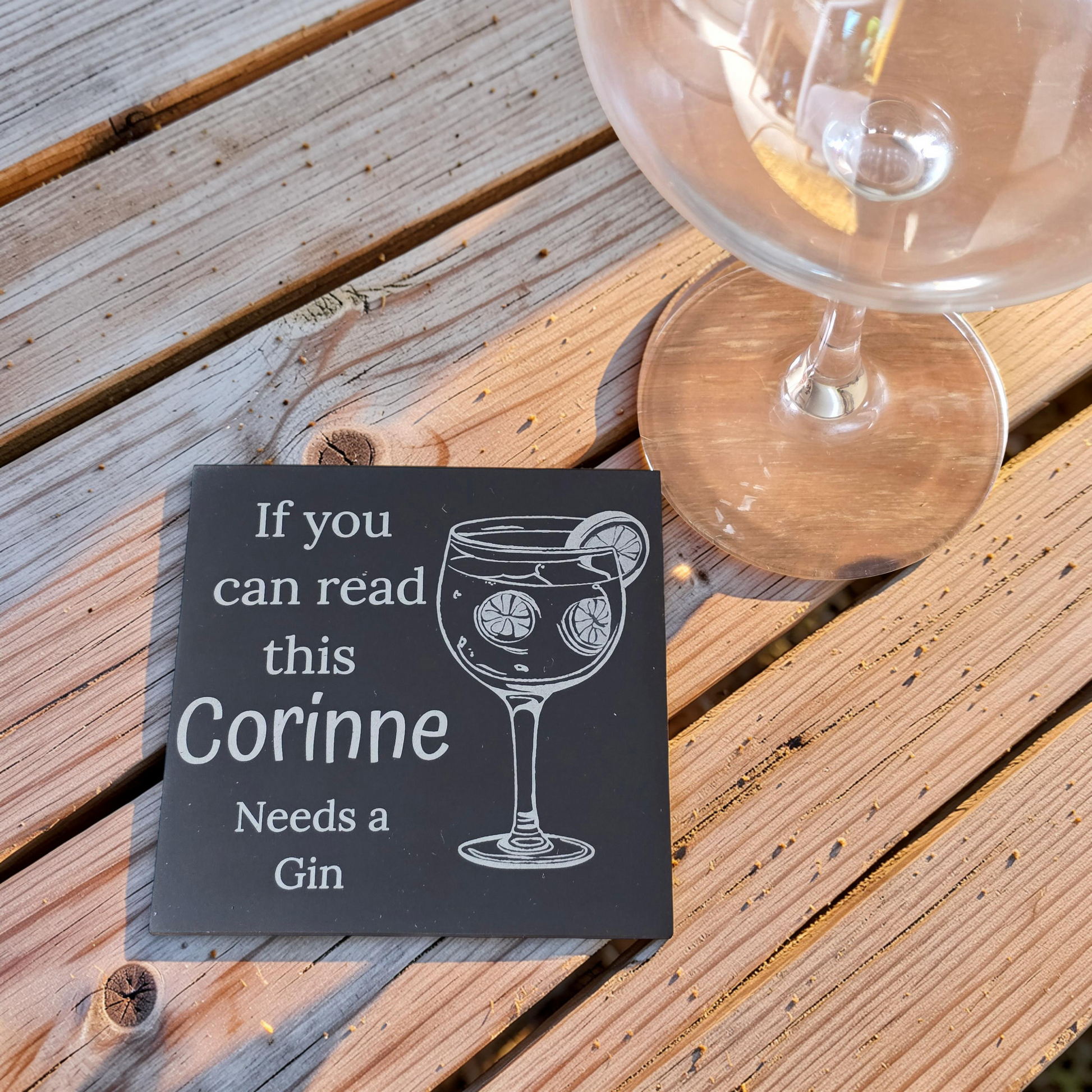 Personalized gin coaster with a gin glass illustration and text on a wooden surface with a glass.