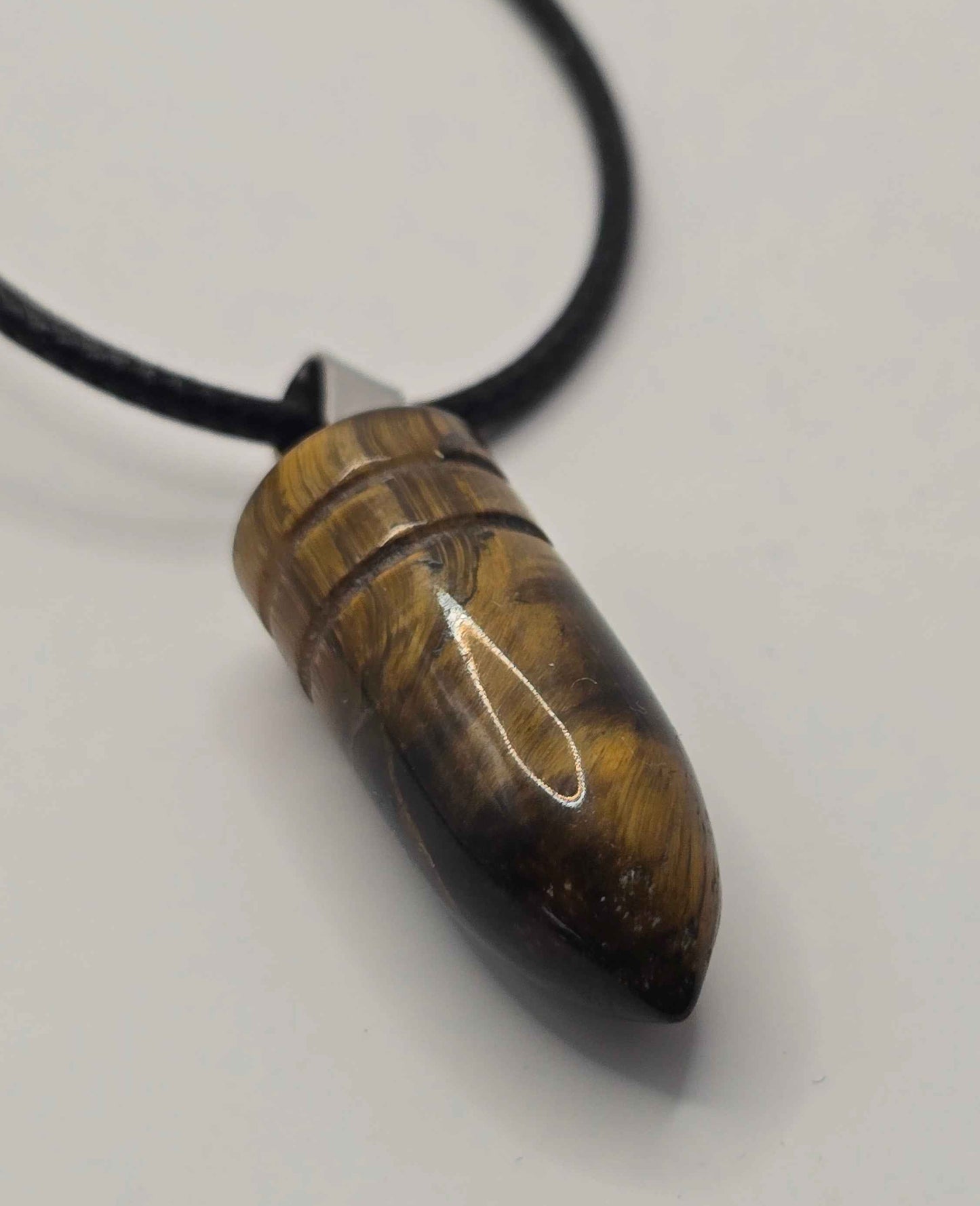 Tortoiseshell pendant on a black cord against a white background