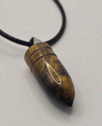 Tortoiseshell pendant on a black cord against a white background