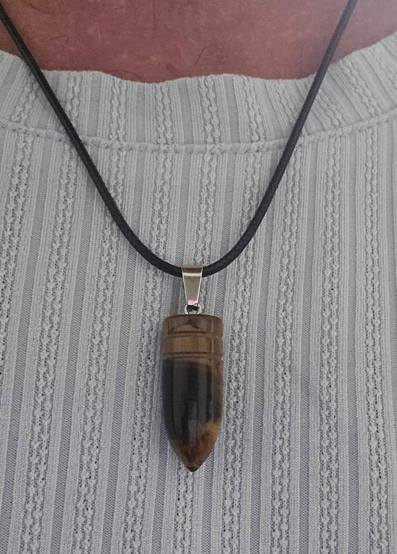 Necklace with a brown tigers eye bullet pendant being worn