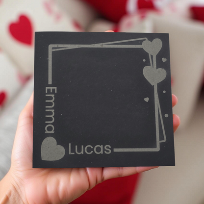 custom square slate coaster with 'Emma' and 'Lucas' engraved, held in a hand.