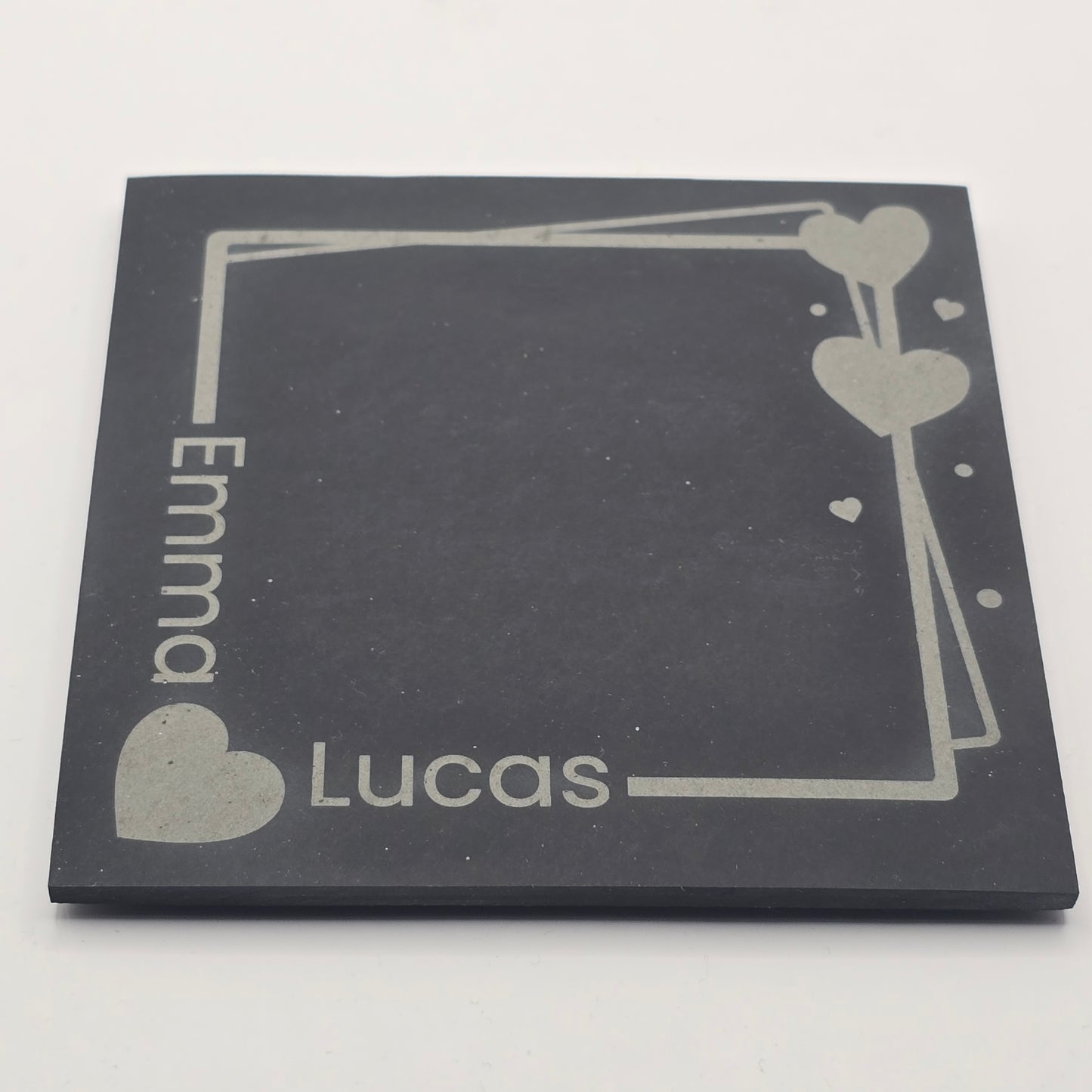 Personalized black slate with engraved names 'Emma' and 'Lucas' on a white background