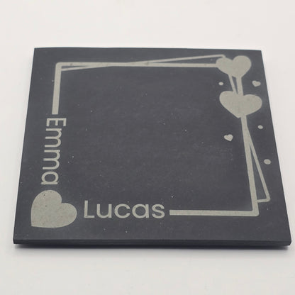 Personalized black slate with engraved names 'Emma' and 'Lucas' on a white background