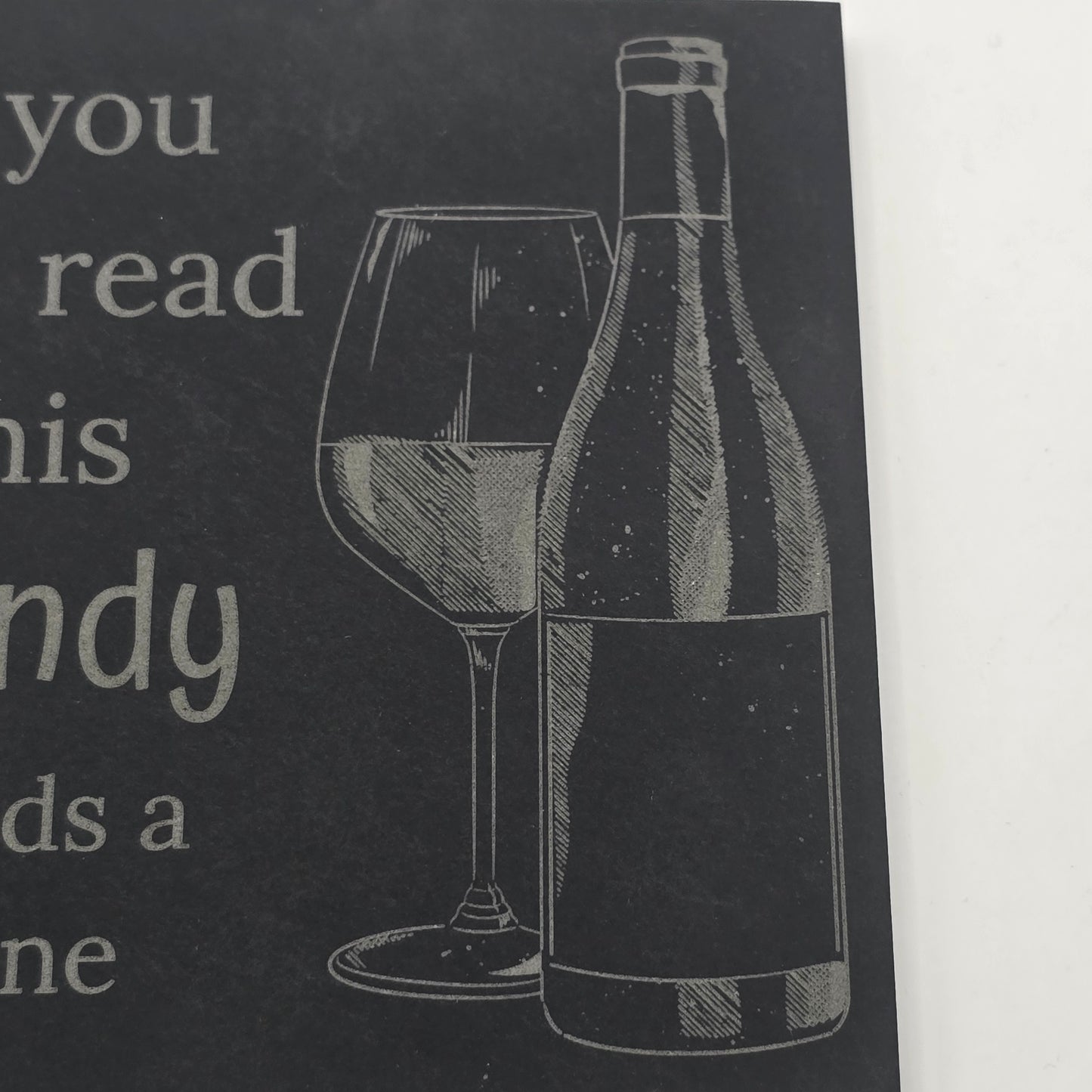 slate coaster with an engraving of a wine bottle and glass