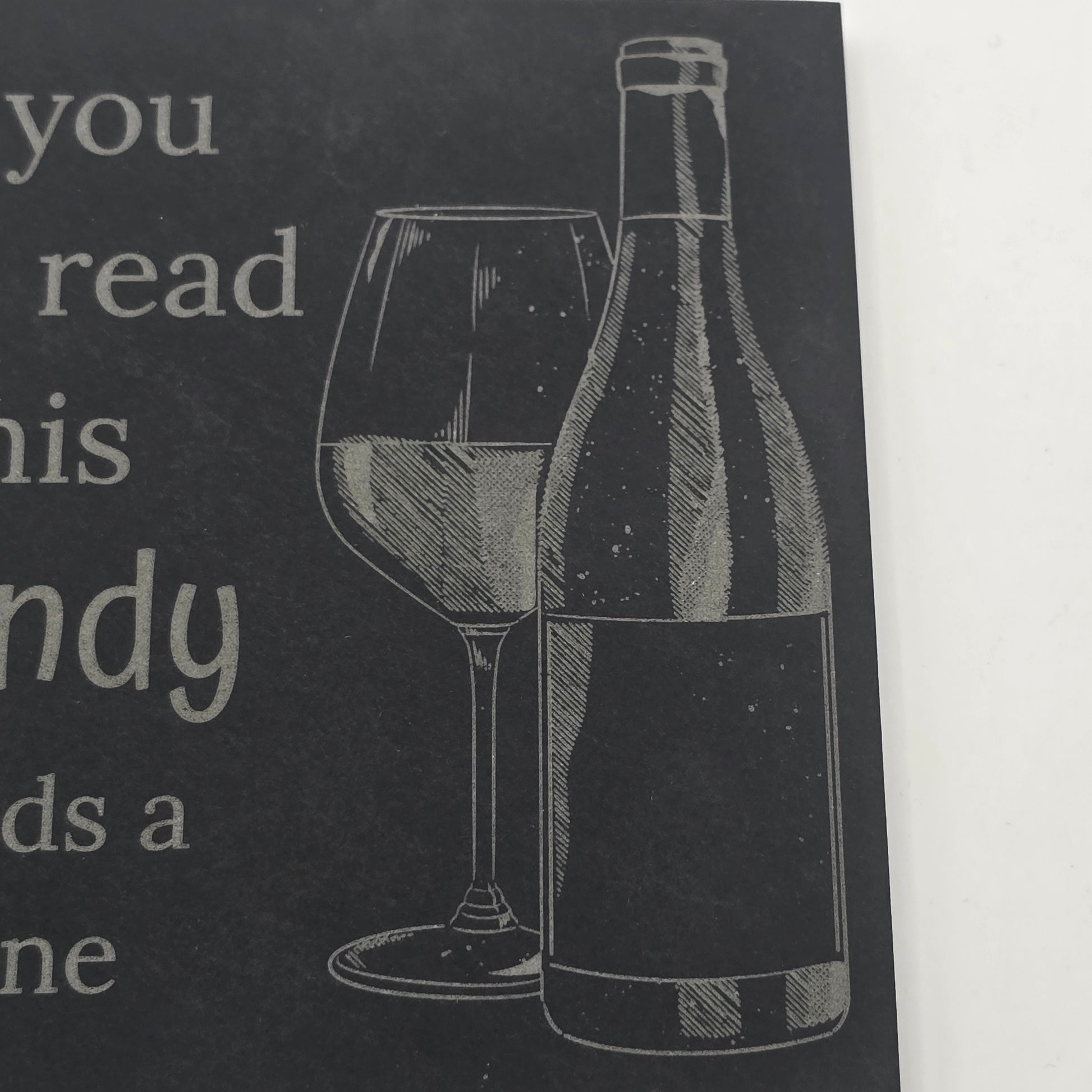 slate coaster with an engraving of a wine bottle and glass