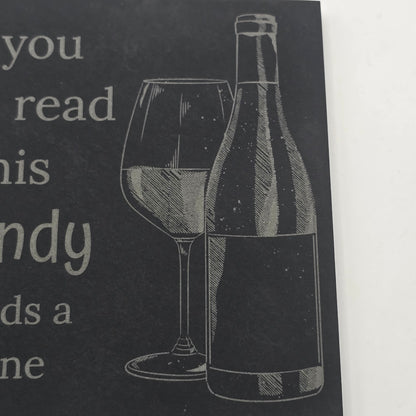 slate coaster with an engraving of a wine bottle and glass