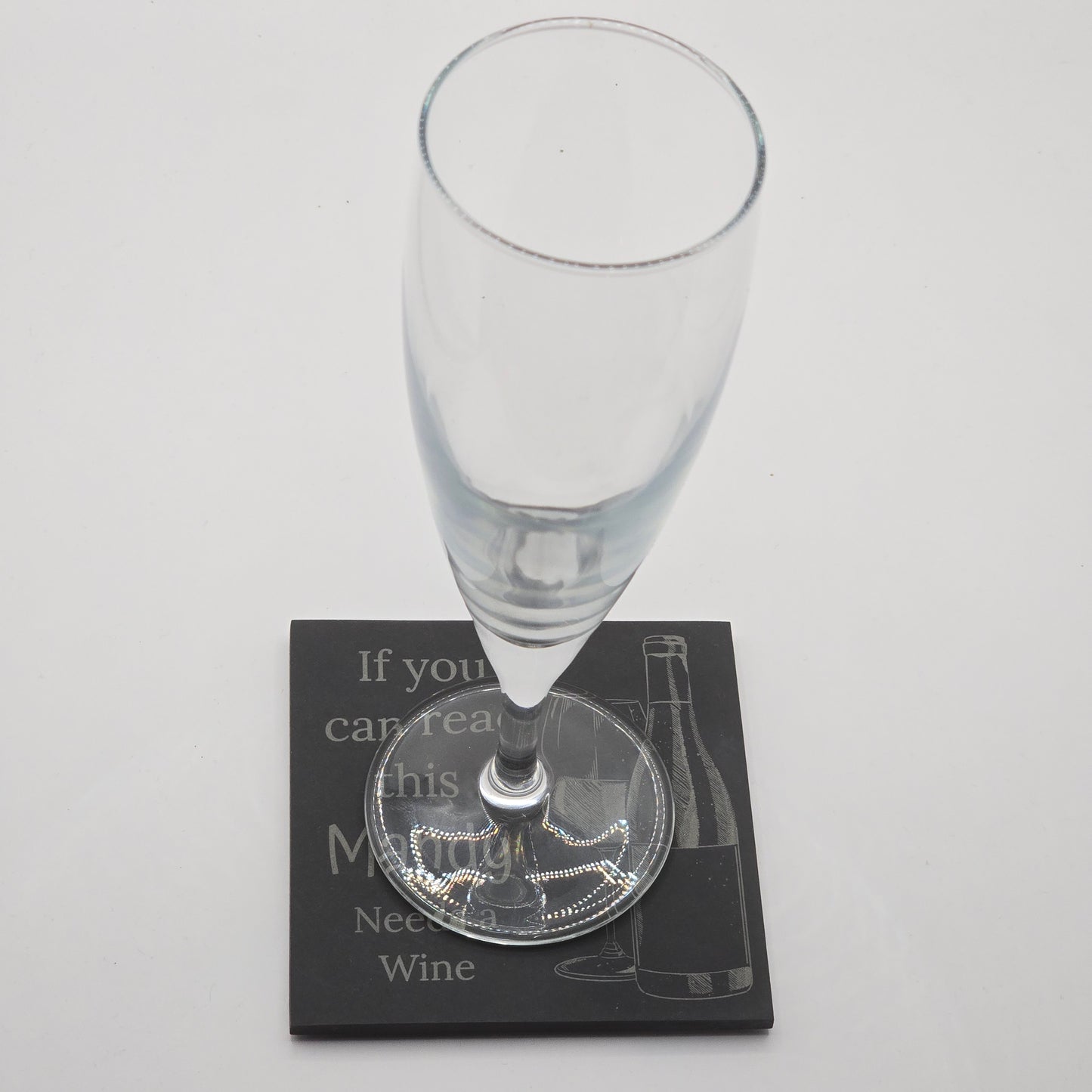 champaign flute resting on a custom coaster with the text "if you can read this Mandy needs a wine"