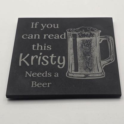 angled shot of a personalised slate coaster with a beer glass engraving and a funny quote