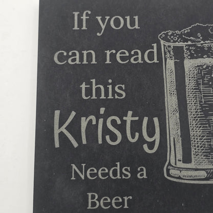Black slate with engraved text 'If you can read this Kristy Needs a Beer' and a glass illustration.