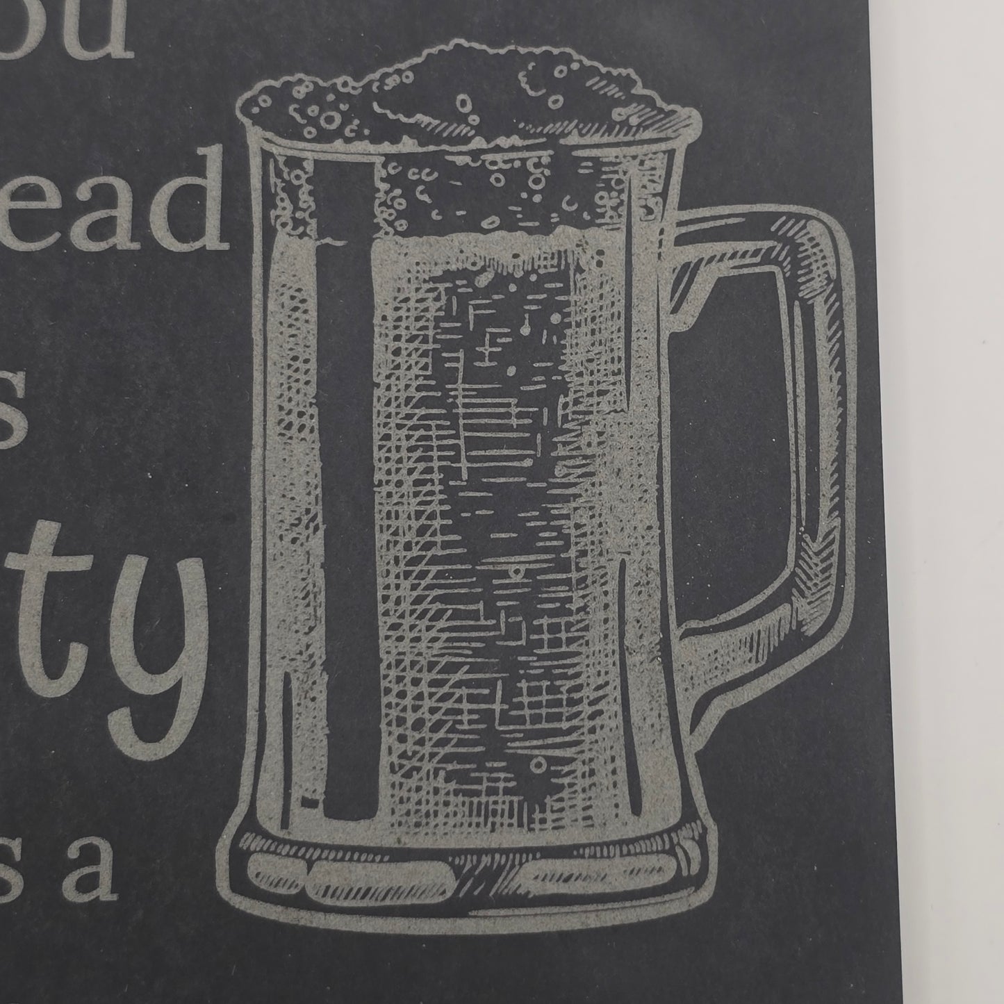engraving of a beer glass on slate beer mat