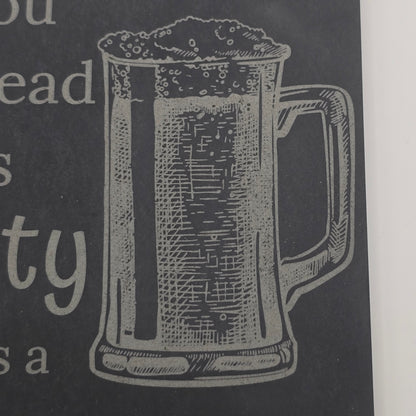 engraving of a beer glass on slate beer mat