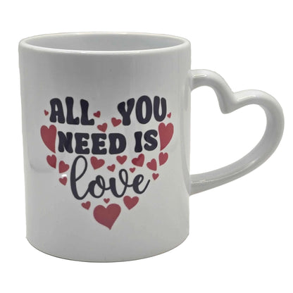White mug with 'All You Need Is Love' text and heart designs. with a heart shaped handle