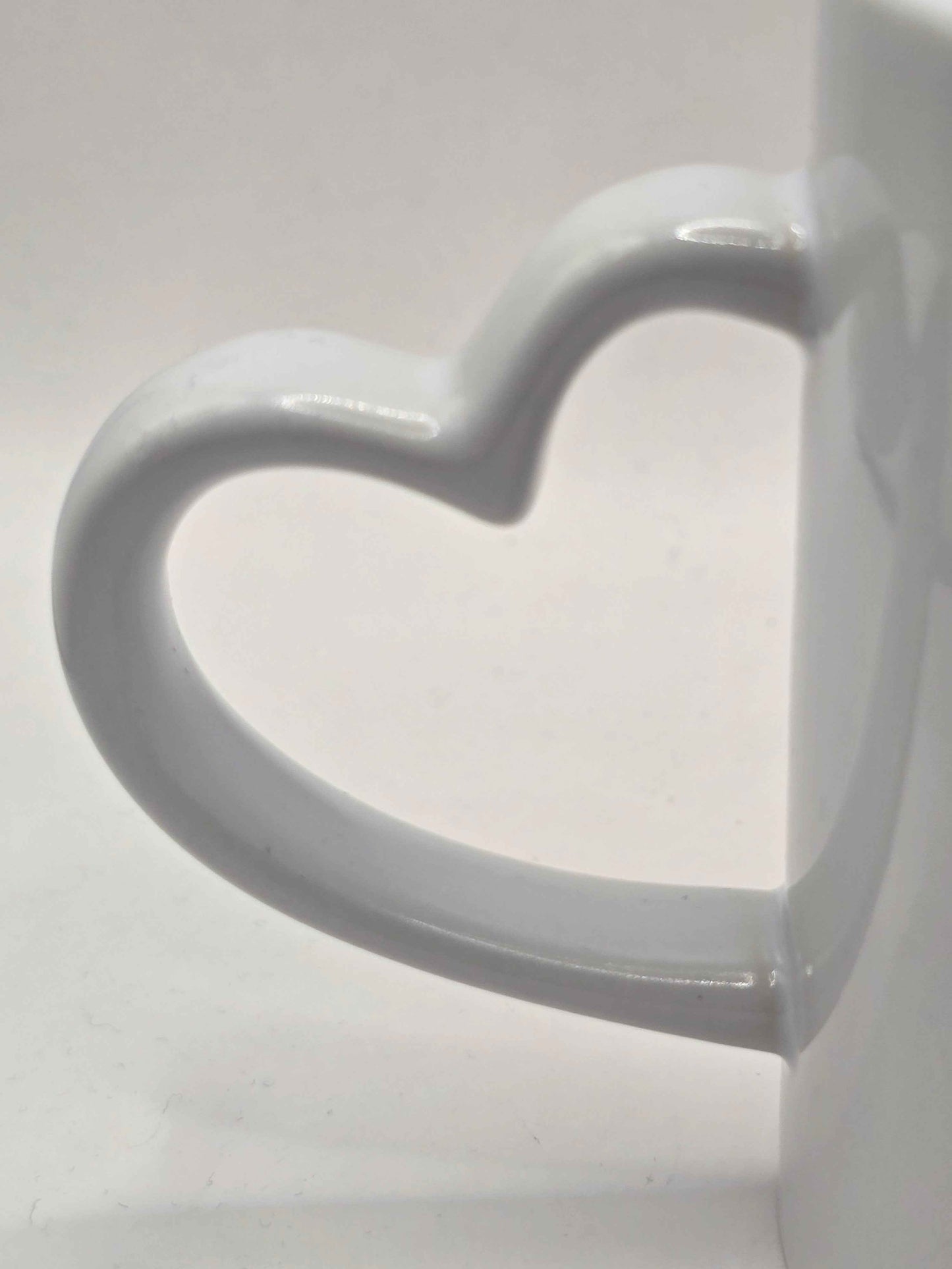 White ceramic mug with a heart-shaped handle on a white background