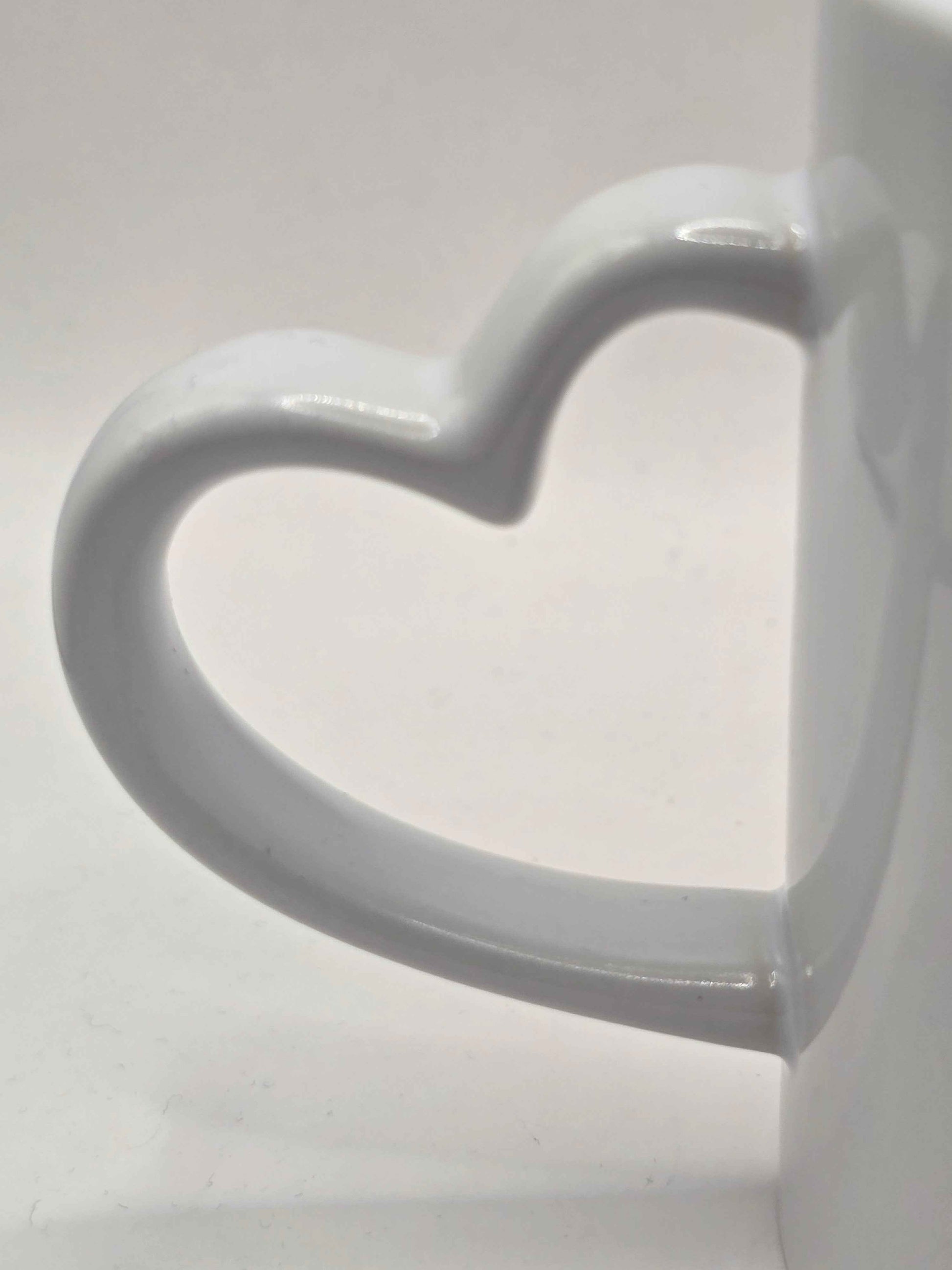 White ceramic mug with a heart-shaped handle on a white background