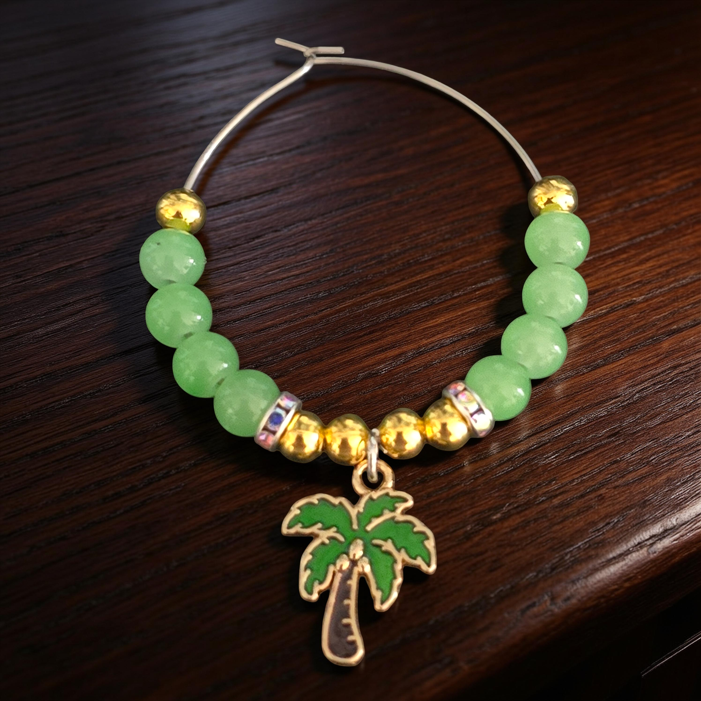 Cocktail glass charm with green beads and gold accents plus a palm tree charm