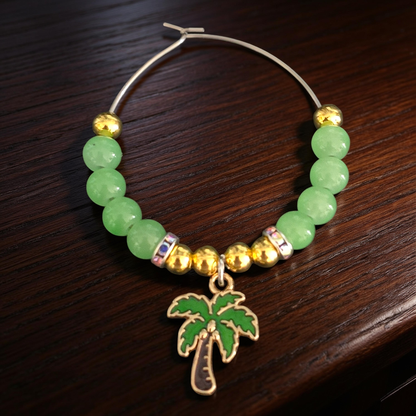 Cocktail glass charm with green beads and gold accents plus a palm tree charm