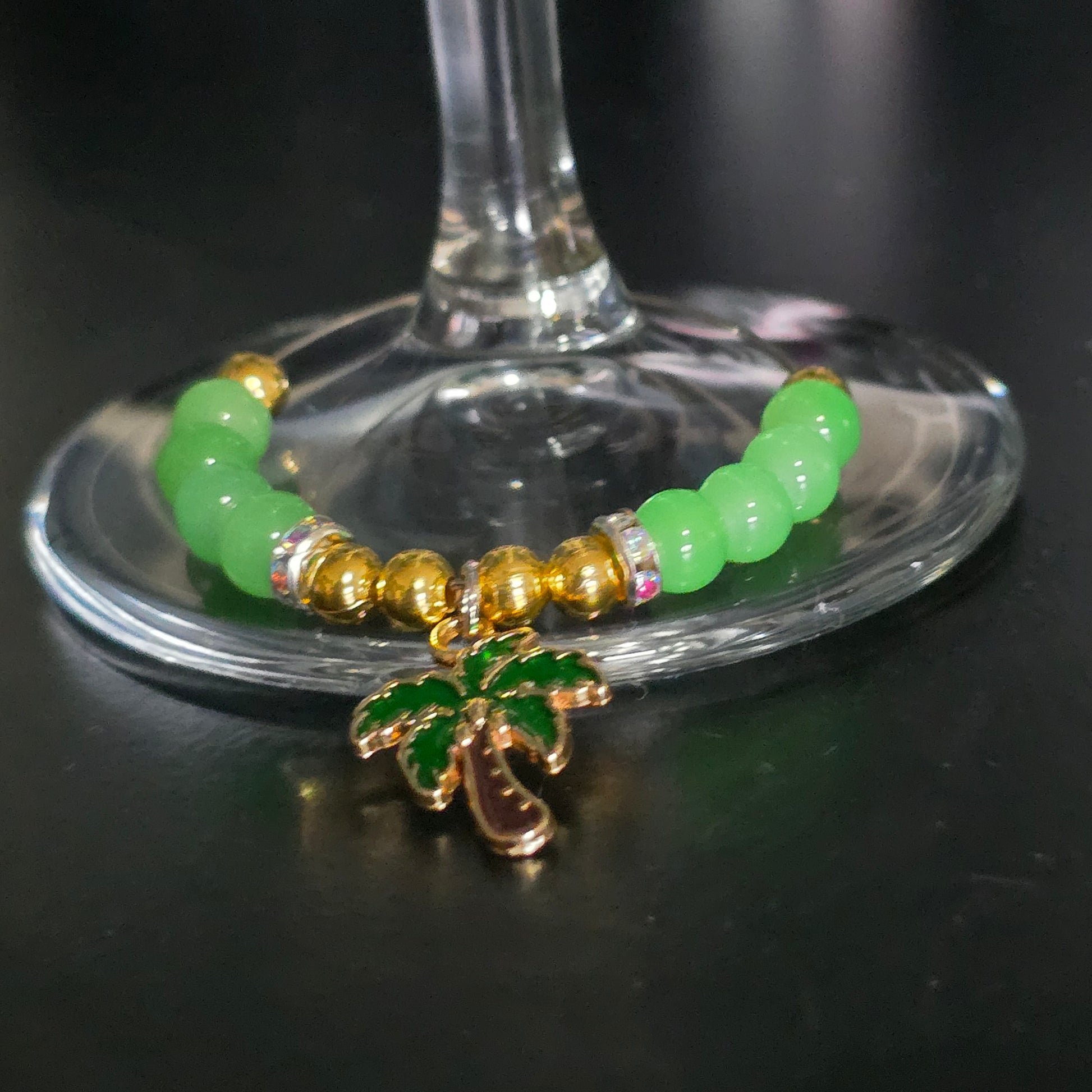 cocktail glass charm with green and gold beads, colourful spacers and a palm tree dangle charm