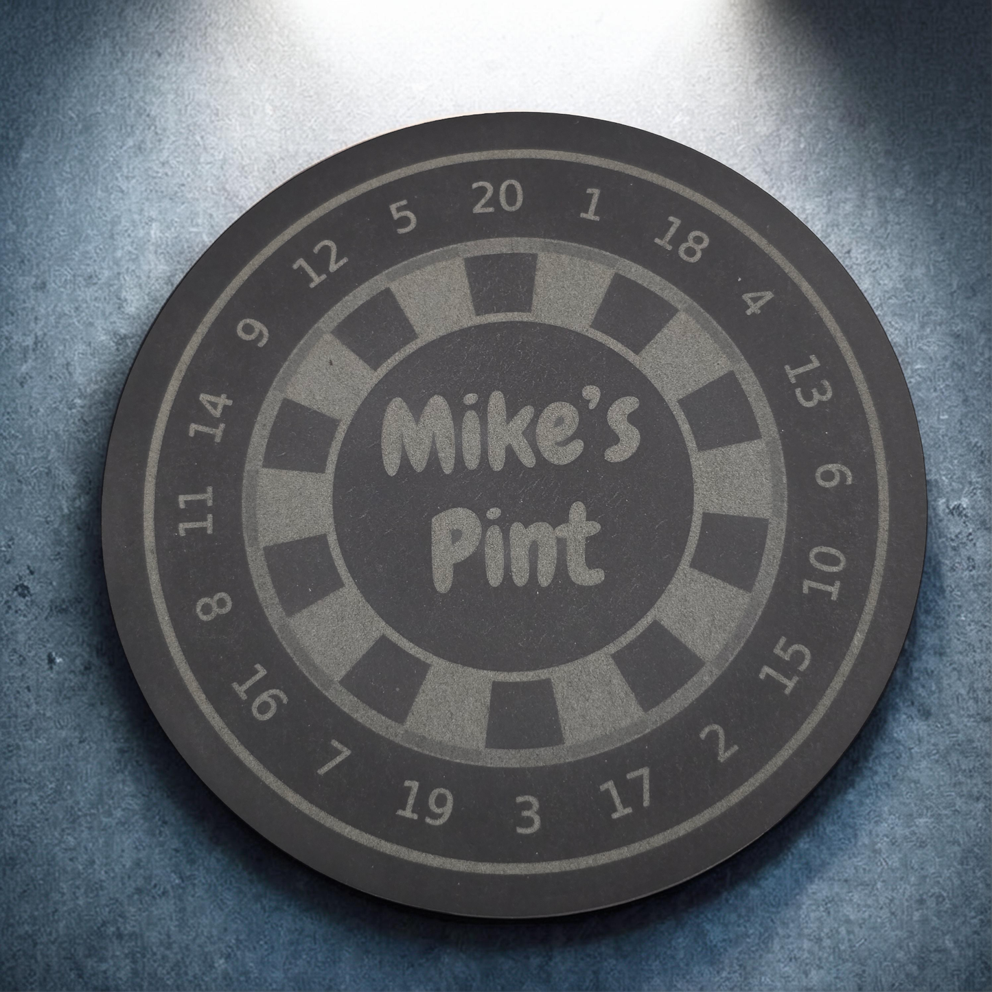 personalised Round slate coaster with 'Mike's Pint' text on a textured surface