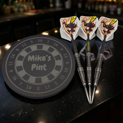 personalised dartboard coaster next to a set a darts
