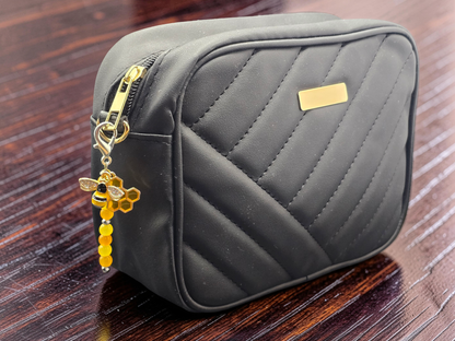 black clutch bag with an orange and yellow handmade bee zipper charm.