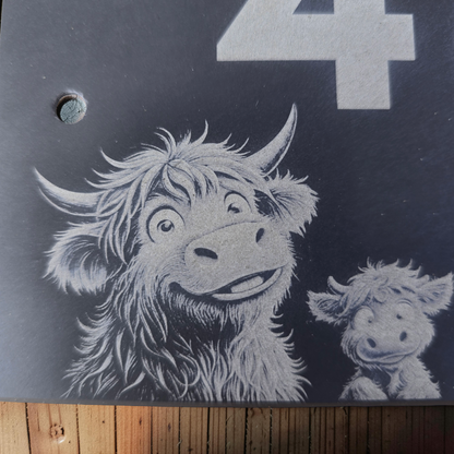 Slate plaque with a design of a highland cow and calf.