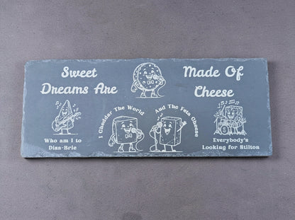 Rectangular slate board engraved with cartoon cheese characters and Sweet Dreams Are Made of Cheese song puns.
