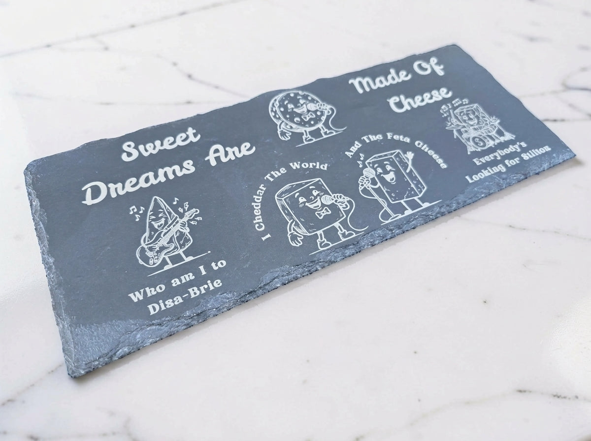 Rectangular slate board engraved with cartoon cheese musicians and cheese-themed Sweet Dreams lyrics.