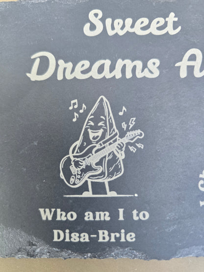 Engraved slate board featuring a cartoon cheese wedge playing electric guitar with the pun Who am I to Disa-Brie.