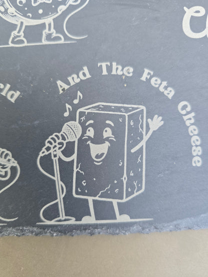 Engraved slate detail of a cartoon feta cheese singing into a microphone under text reading And The Feta Cheese.