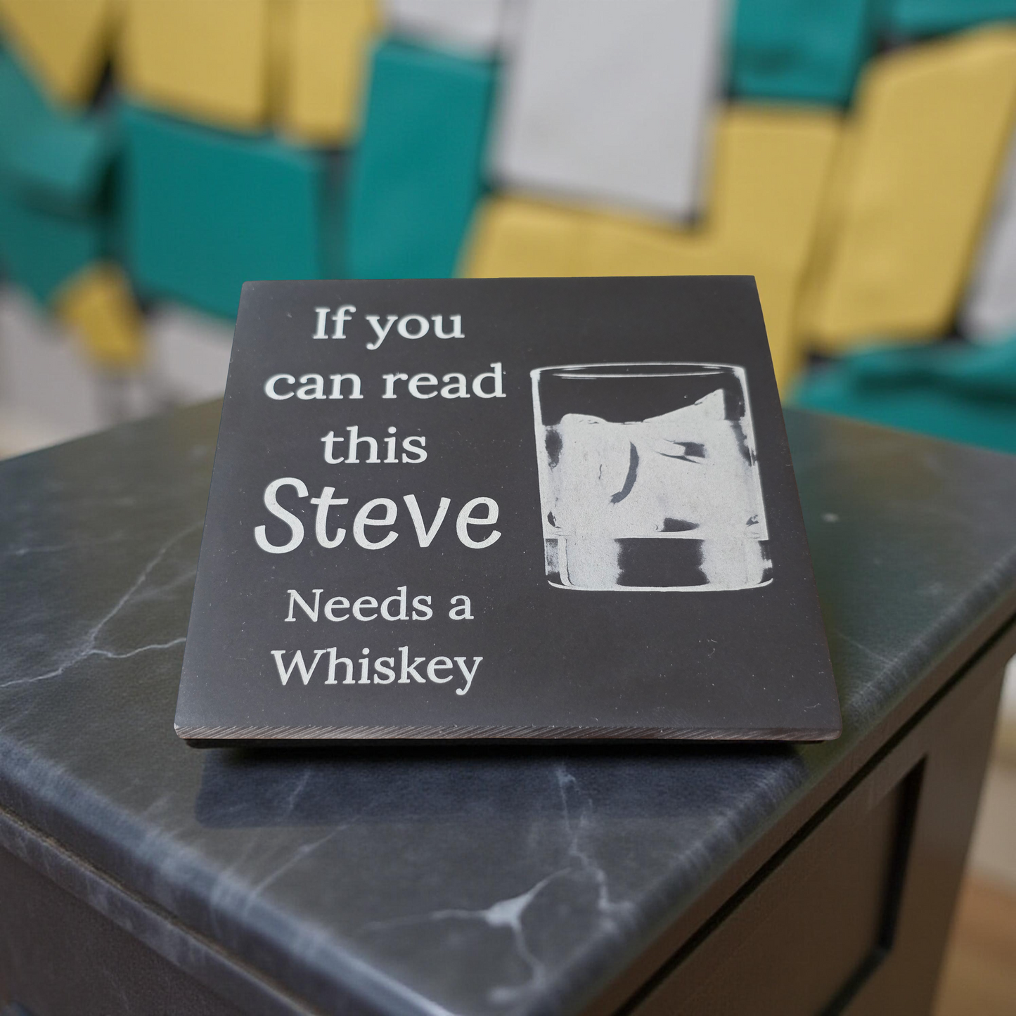 Slate Coaster with text 'If you can read this Steve Needs a Whiskey' on a marble surface.