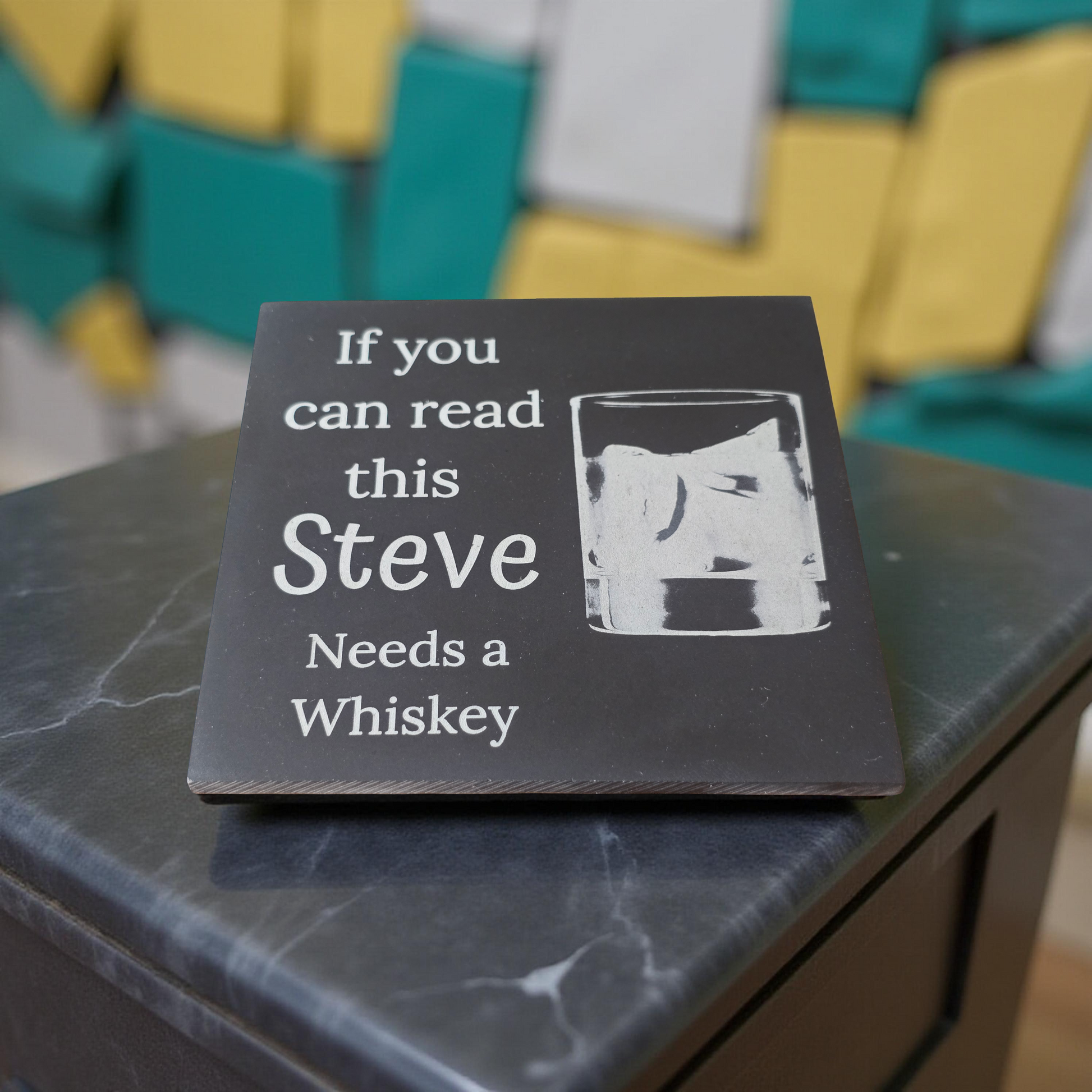 Slate Coaster with text 'If you can read this Steve Needs a Whiskey' on a marble surface.