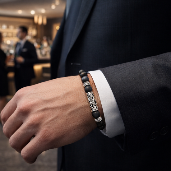man wearing a matt black beaded bracelet walking through a bar