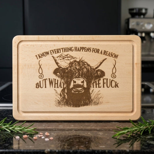 Beech wood cutting board with a highland cow illustration and funny quote text on a kitchen counter.